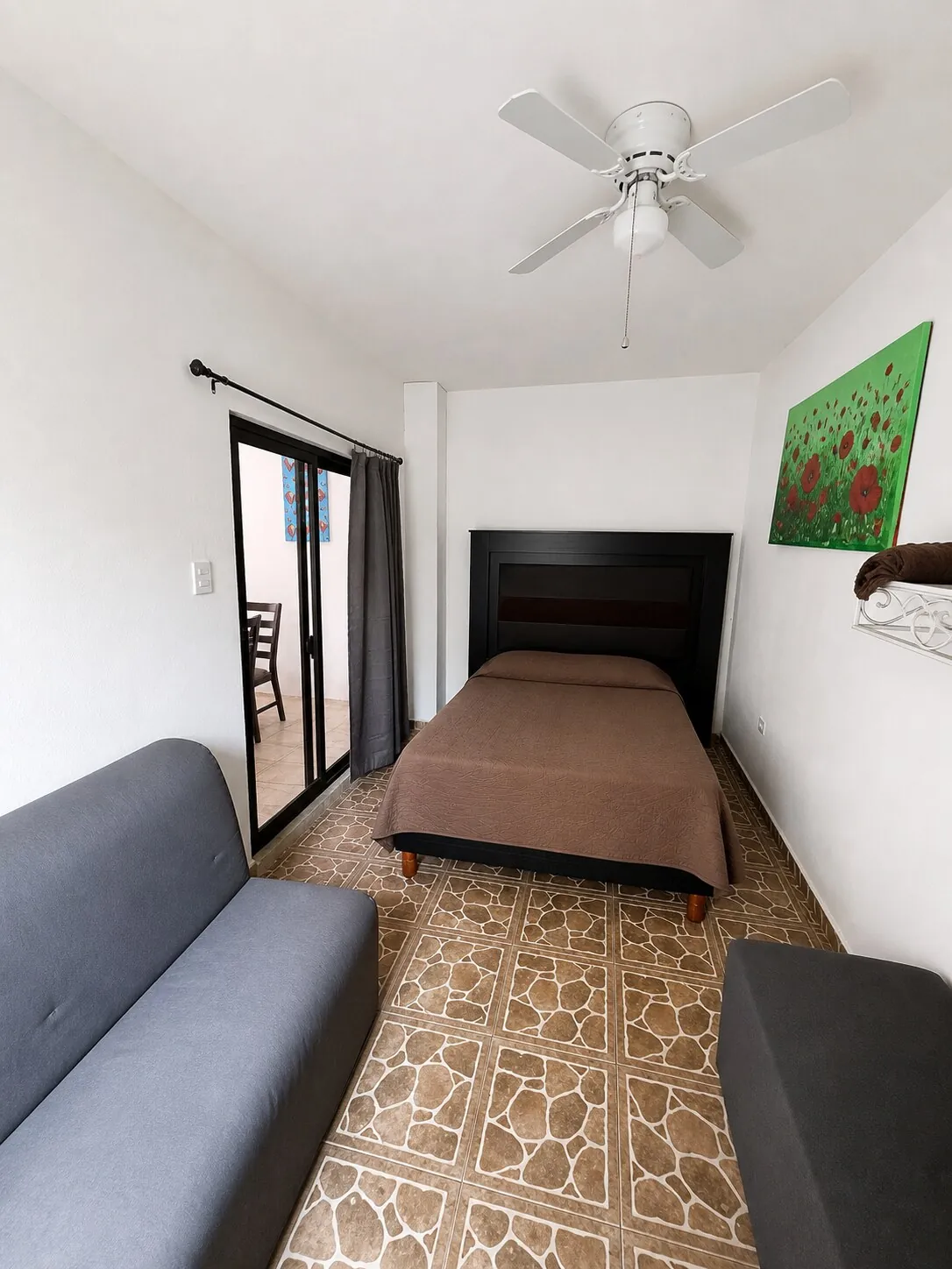 Recámara con cama matrimonial y sofá